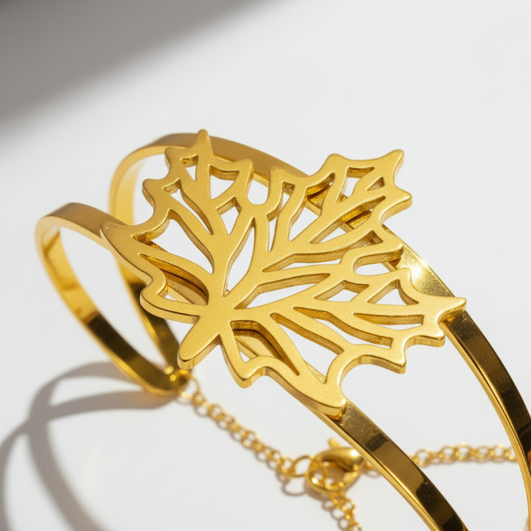 Close-up angled view of autumn leaf bracelet showing detailed leaf veins and 24K gold plating with safety chain